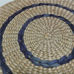 Handcrafted cattail straw meditation cushion detail view, natural woven tatami round floor mat texture.