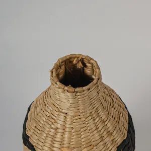 Gros plan sur le col du vase en paille avec texture de fibre naturelle pour déco rustique.