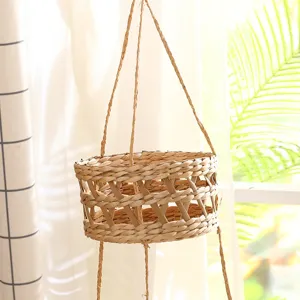Détail de panier suspendu tissé à la main, paille naturelle pour décoration rustique.