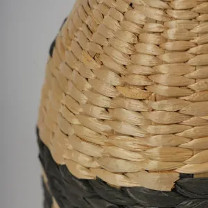 Gros plan sur la texture d'un vase en paille tissée, présentation de panier déco.