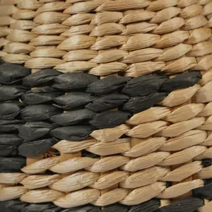 Gros plan détaillé sur la texture du vase tressé en jonc de mer, déco rustique élégante.