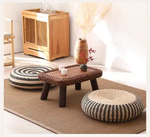 Detail shot of Japanese straw woven floor cushion and tatami decor scene in warm natural light.