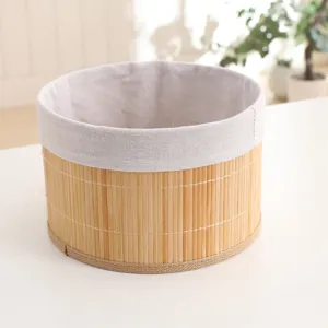Detailed close-up of a woven bamboo storage basket with fabric lining on a white table.