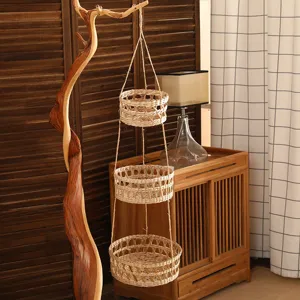 Panier suspendu à trois niveaux tissé à la main pour décoration murale et rangement.