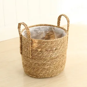 Handmade woven seagrass storage basket with handles and plastic liner for plants home decor.