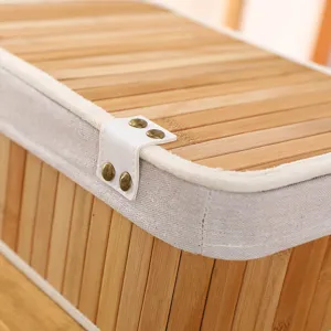 Boîte de rangement en bambou fait main détail lattes tissées bord tissu rivets près.
