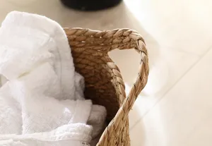 Handwoven straw storage basket with white fabric liner, natural home decor organizer detail.