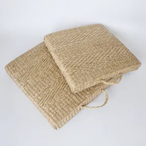 Square woven rush grass cushion with handle, natural plant material for home floor and bay window.