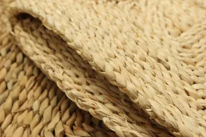 Close-up detail of natural corn leaf woven mat, showing neat braided texture and craft.