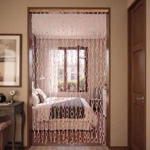 Rosa Kettenglied-Türvorhang im Türrahmen hängend, gemütliche Schlafzimmer-Szene im Detail.
