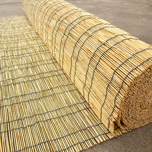 Dettaglio rotolo tenda in canna naturale che mostra trama tessuta per ombreggiatura finestra.