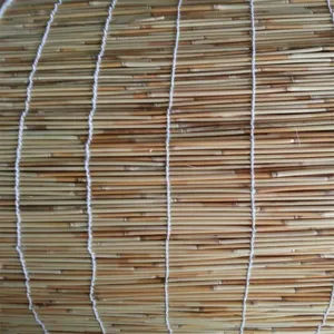 Primo piano sui dettagli del materiale della tenda in canna intrecciata naturale, con una trama pulita.