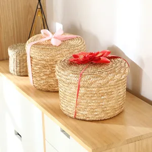 Detailed view of round straw storage basket with lid and ribbon, ideal for gift packing.
