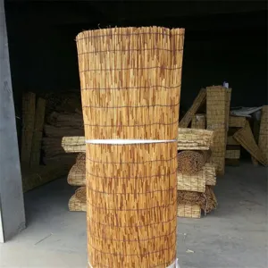 Dettaglio rotolo tenda intrecciata in canna carbonizzata per decorazione d'interni.