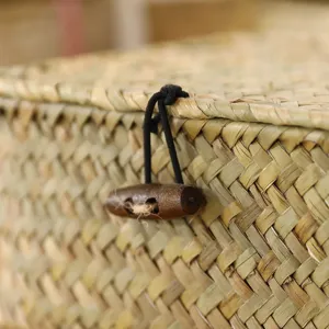 Close-up detail of woven storage basket showing natural straw texture and wooden toggle