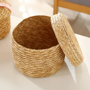 Round woven straw storage basket with lid, natural handmade desktop organizer for gifts.