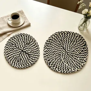 Detail shot of black and white woven placemats set, natural straw table mats for kitchen decor.
