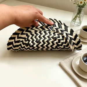 Handmade black and white woven placemat, stylish braided pot holder for home kitchen decor.