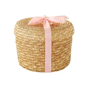 Round straw woven storage basket with lid and pink ribbon bow, perfect gift box for wedding.