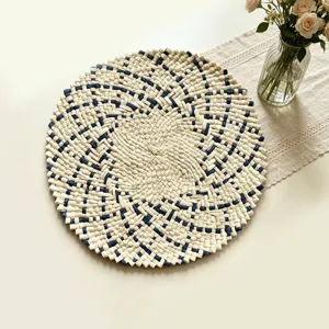 Detailed view of hand-woven round placemat in beige and blue, perfect for kitchen table decor.