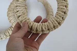 Close up detail of hand woven corn husk straw trivet texture and tight braid construction.
