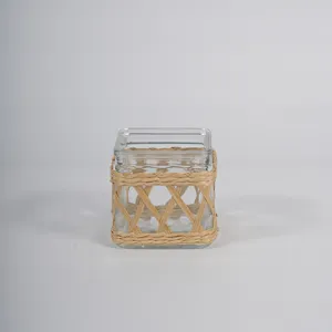 Rattan woven glass vase detail, handmade wicker wrap on clear glass container for decor.