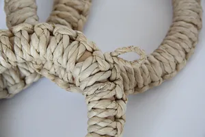 Detailed close-up shot of hand-woven corn husk trivet, showing natural texture and plant material.