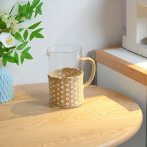 Handmade straw woven glass cup sleeve with handle, rustic lifestyle pitcher detail and decor.