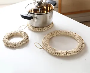 Detailed view of handmade corn husk woven hot pads, natural straw trivet on clean table.