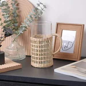 Handmade rattan wrapped glass cup detail showing natural straw sleeve and tabletop decor style.