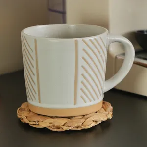 Detailed view of a ceramic mug resting on a hand-woven natural water hyacinth coaster.