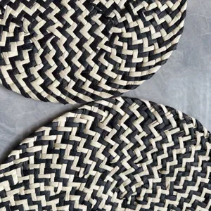 Close-up detail of black and white woven placemat, eco-friendly straw heat-resistant kitchen pad.