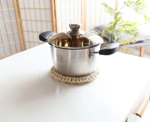 Stainless steel stock pot with glass lid and heat-resistant handles for kitchen cooking use.