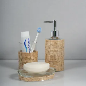 Hand-woven straw glass bathroom accessory set, including soap dispenser, cup and soap dish.