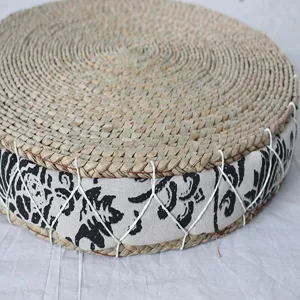 Round hand-woven straw cushion detail showing natural texture and patterned side.