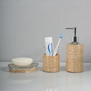 Natural straw woven bathroom set detail featuring soap dispenser, glass tumbler and soap dish.