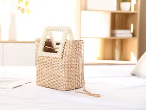 Handmade straw woven bag with elegant pearl handle and metal chain for summer beach use.