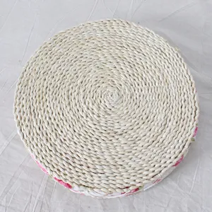 Detailed view of handmade straw woven cushion with edge lace, natural round mat.