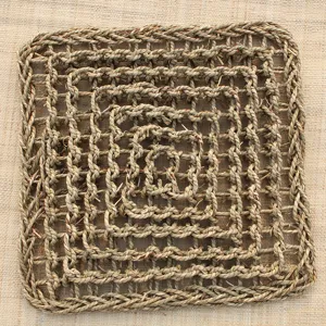 Detailed view of woven straw pet scratching mat with square grid design for cats.