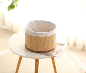Close-up van ronde geweven opbergmand met stoffen voering op een witte tafel in kamer.