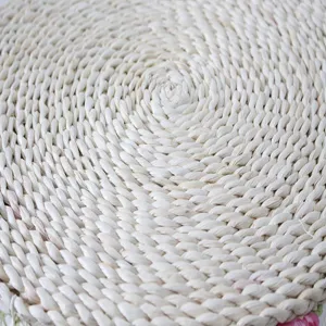 Handmade straw woven cushion detail, natural round tatami mat texture close up.