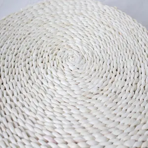 Handcrafted round straw woven cushion detail, natural plant fiber texture, cozy home decor seat pad.