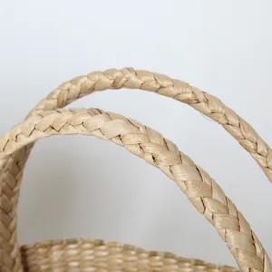 Handcrafted straw woven beach bag with sturdy braided handles, perfect for summer vacation.