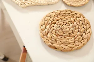 Close-up detail view of natural straw woven round placemat, rustic table decor texture.