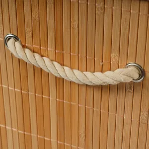 Bamboo storage basket detail close up with twisted rope handle and metal grommets.