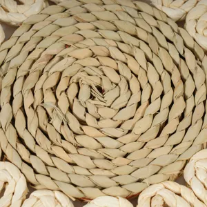 Handmade straw woven coaster detail, natural corn husk round placemat texture view.