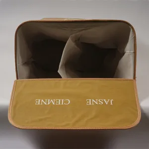 Double compartment bamboo woven laundry basket with flip lid and fabric inner lining.