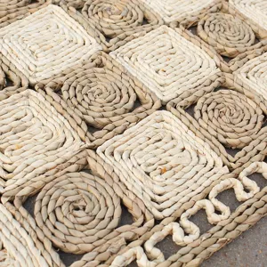 Handcrafted straw woven mat detail, natural plant fiber texture close up shot, rustic home decor.