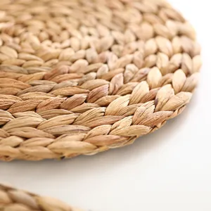 Close-up detail of natural woven straw placemat showing texture and tight braiding pattern.