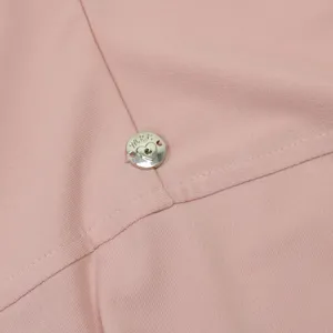 Primo piano del tessuto in cotone cristallo elastico rosa con bottone logo in metallo.